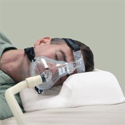man wearing a CPAP on a pillow